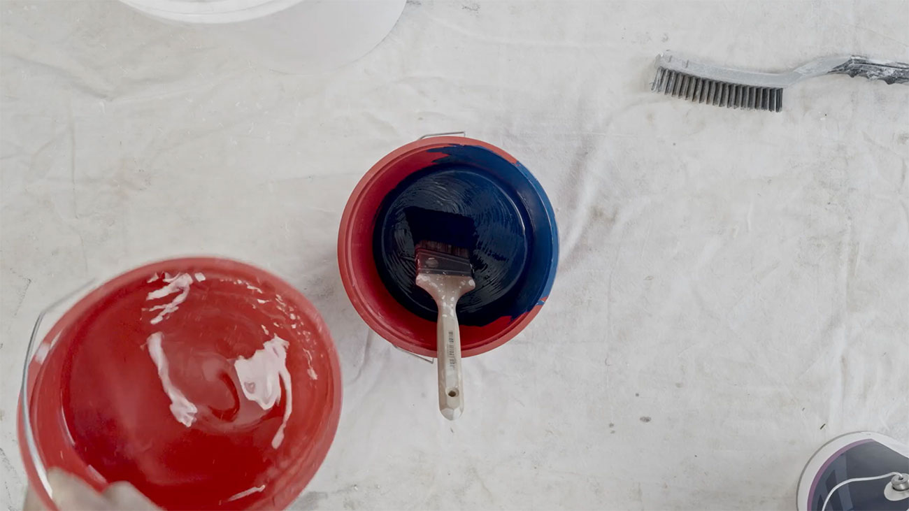 A red bucket with a paint brush in it